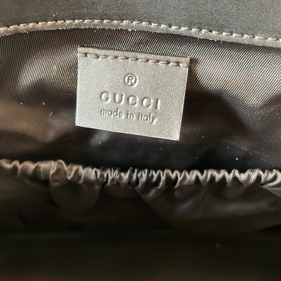 Black Gucci diaper bag with blue and red strap.